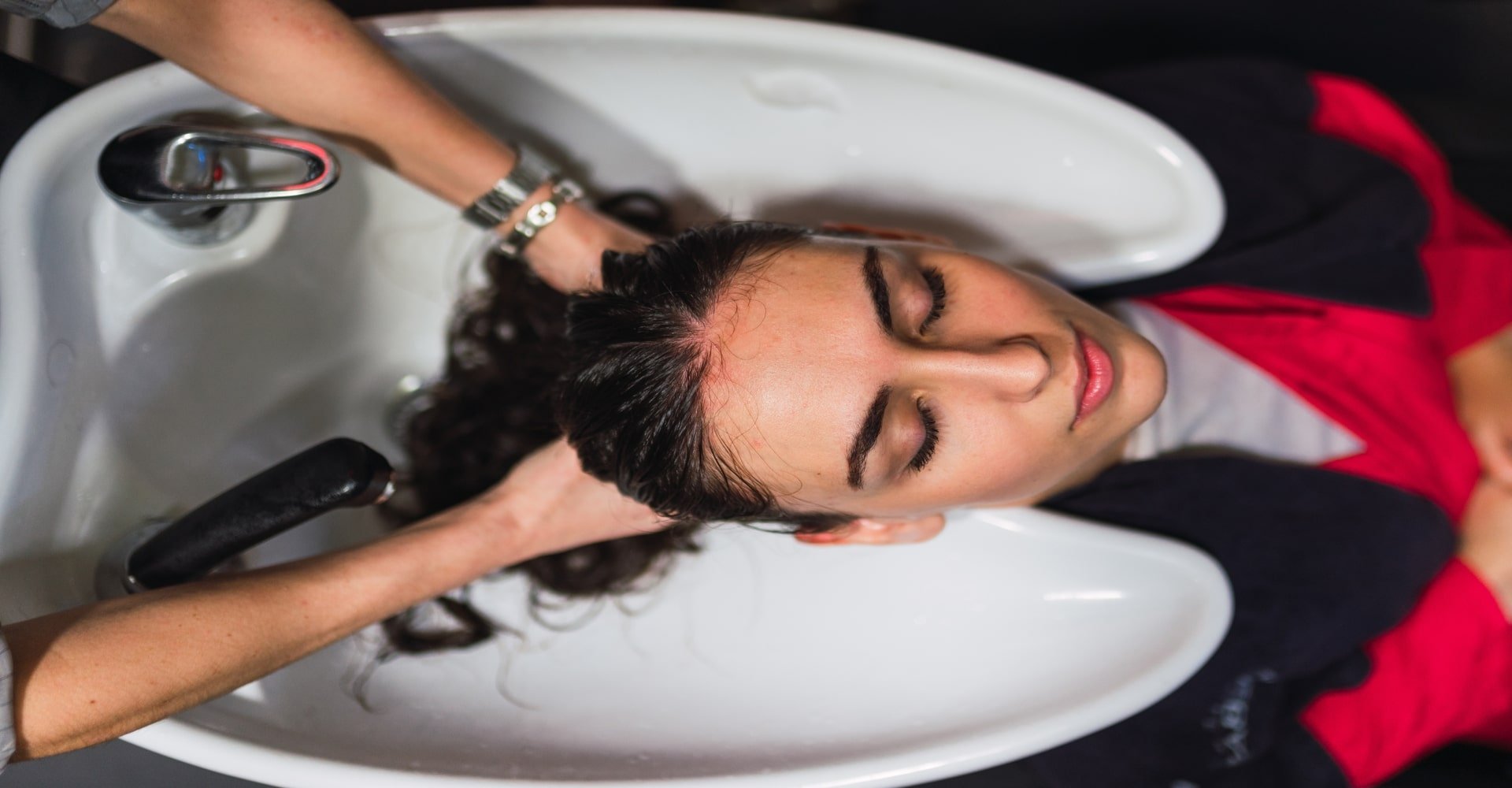 Profissional lavando o cabelo de modelo branca